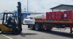 A forklift loading cargo onto a truck at a supply base.