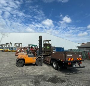 Worker using a forklift to load goods onto the truck.